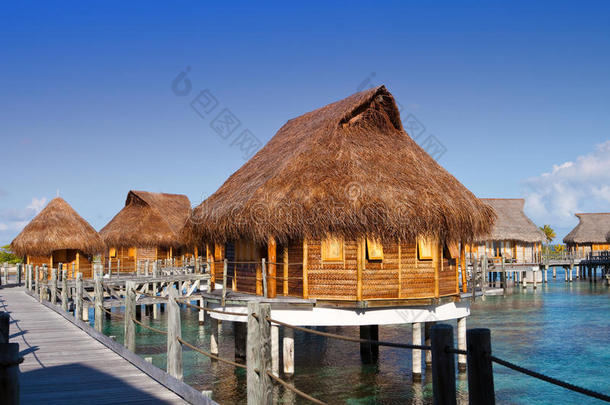 在温暖的阳光下，在海上有稻草屋顶的房子