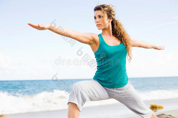 年轻漂亮的女人在海滩上练瑜伽