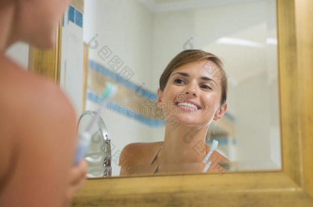 快乐的年轻女子刷牙后检查牙齿