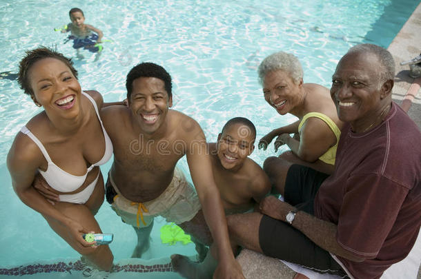男孩（7-9岁）在游泳池与<strong>父母</strong>和祖<strong>父母</strong>抬高的看法肖像。