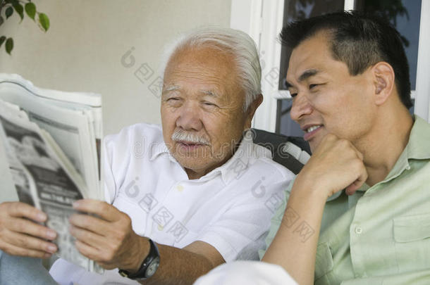 父子俩在户外看报纸