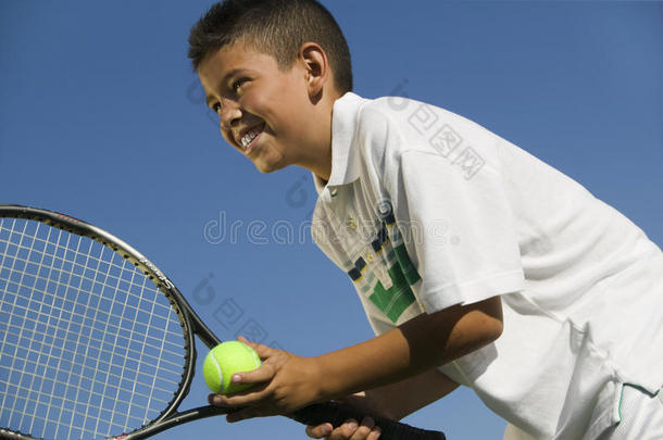 少年少年在<strong>网球场</strong>准备近距离低角度发球