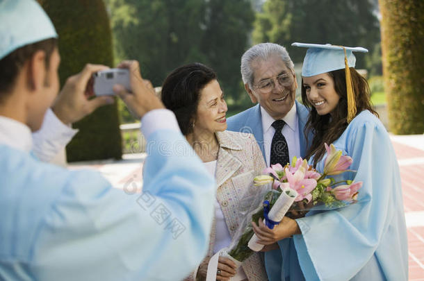 毕业生在外面给其他毕业生和祖父母拍照