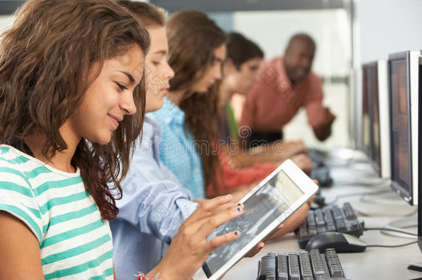 在电脑课上使用数字平板电脑的女孩