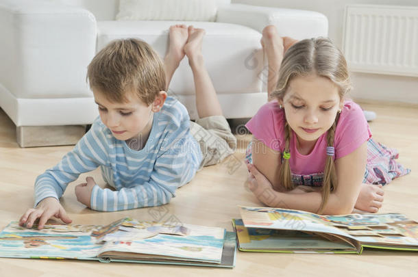 兄弟姐妹在客厅地板上读故事书