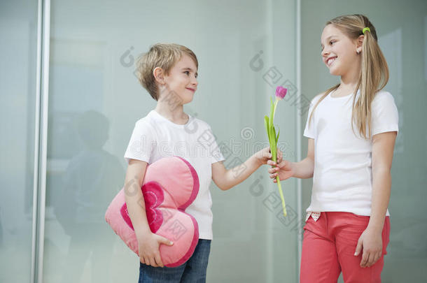 心形靠垫的小男孩给女孩送花