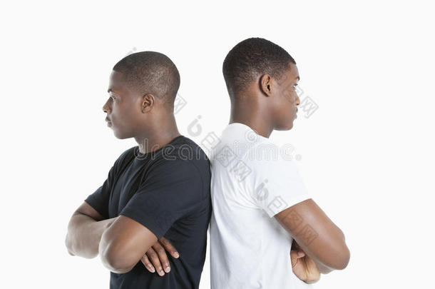 两个男朋友背靠背地站在灰色的背景上