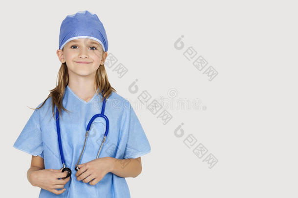灰色背景下身着外科医生服装的年轻女孩的画像