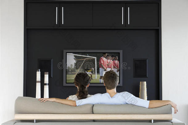 在客厅<strong>电视</strong>上<strong>观看</strong>足球比赛的夫妇的背景