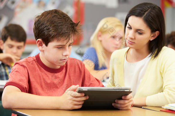 学生与老师一起使用数码平板电脑
