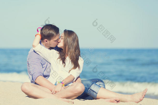 年轻男女在沙滩上接吻的画像