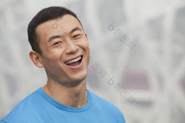 中国北京户外穿着蓝色t恤微笑的年轻运动员的特写照片