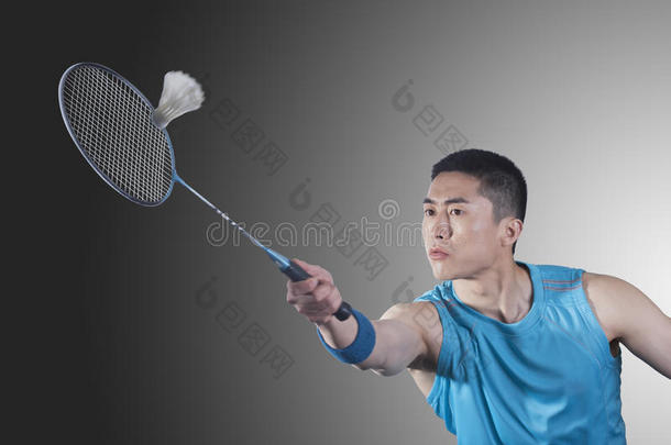 专心打羽毛球、击球的年轻人