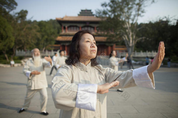 中国人在中国传统建筑前练习太极拳