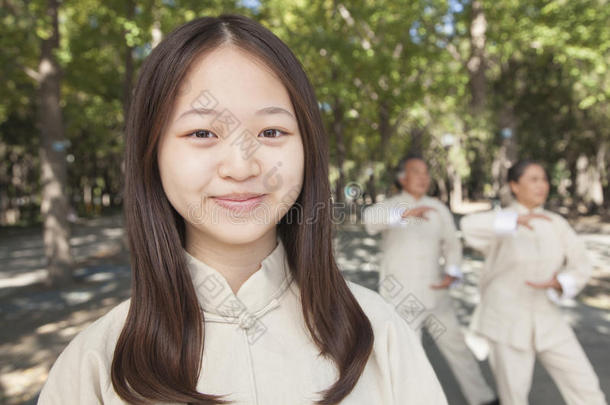 微笑的孙女和爷爷奶奶在公园练太极