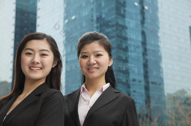 两位年轻快乐的女商人在摩天大楼外的画像
