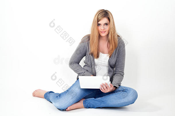 坐在地板上用笔记本电脑工作的妇女