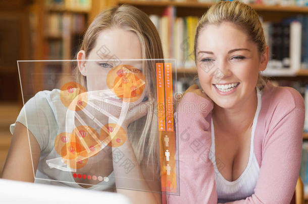 两个微笑的学生看着笔记本电脑和未来的界面