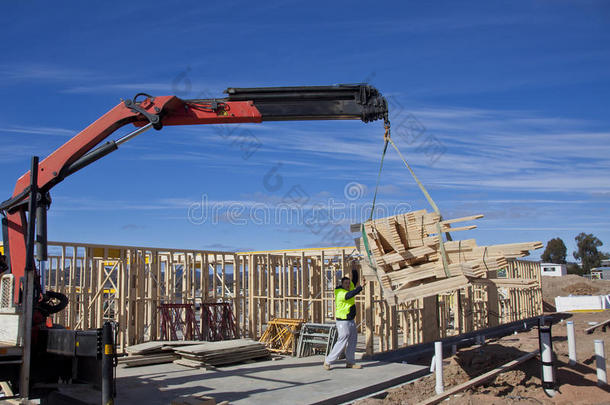 起重机将桁架吊到正在建造的新房上