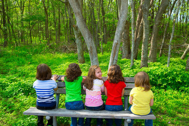 坐在森林公园长凳上的小妹妹和<strong>小朋友</strong>