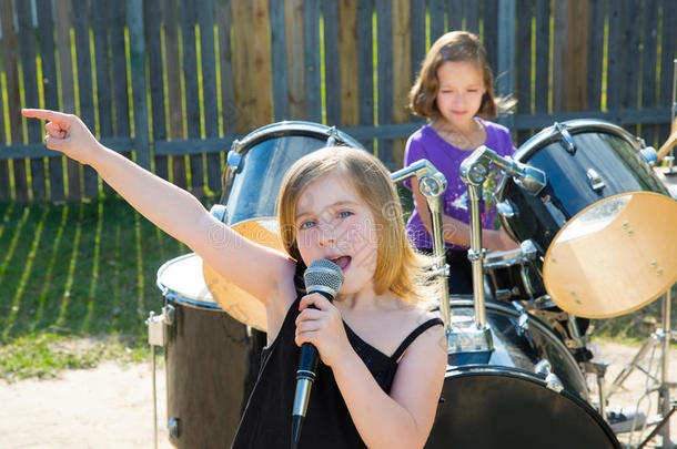 儿童歌手女孩在后院现场演奏乐队
