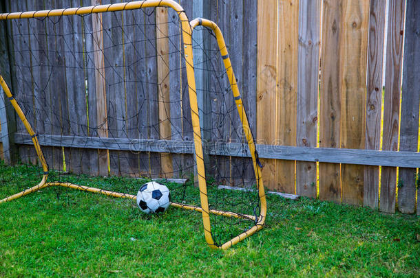 后院带墙木栅栏的儿童足球赛