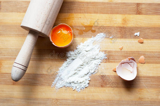 面团鸡蛋，面粉，木板上的擀面杖
