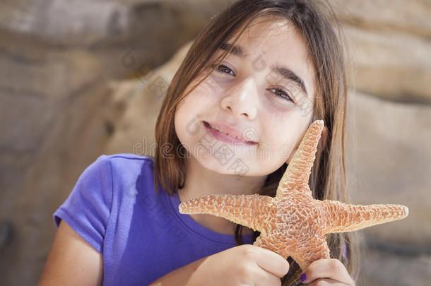 可爱的小女孩在玩海星