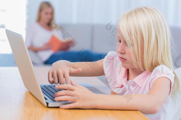 <strong>小女孩在</strong>妈妈<strong>躺在沙发上</strong>看书时用笔记本电脑