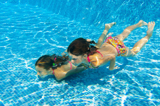 快乐活泼的水下儿童在游泳池里游泳