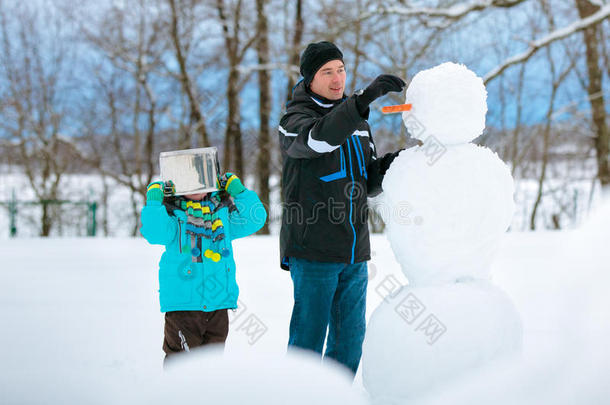 小男孩和他父亲堆雪人