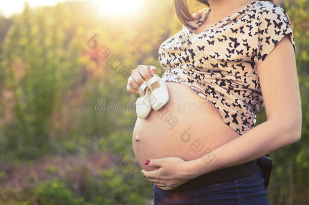 带婴儿小鞋子的难辨孕妇特写