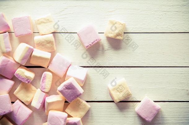 白色木桌上的粉色和白色棉花糖