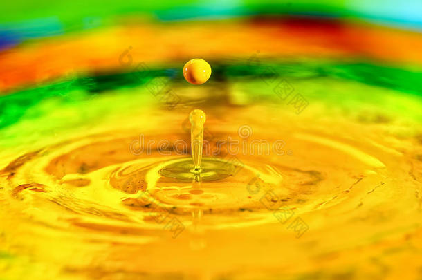 一滴黄色的液体水滴溅在液体油漆上