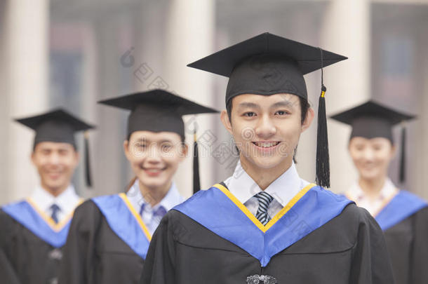 四名大学毕业生面带微笑，看着镜头