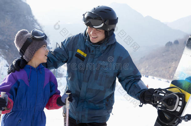 带滑雪用具的父子俩在滑雪场