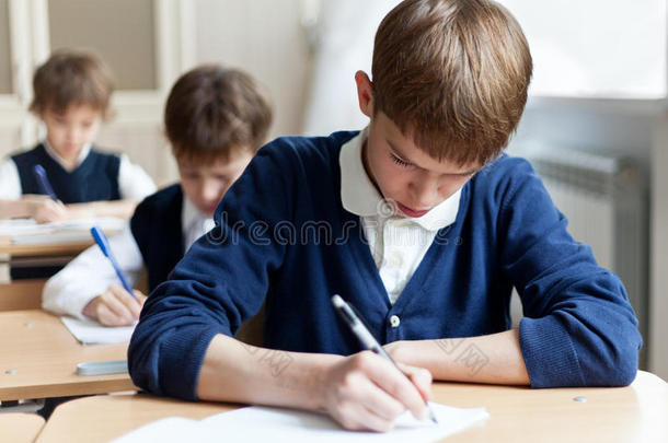 勤奋的学生坐在课桌旁、教室里