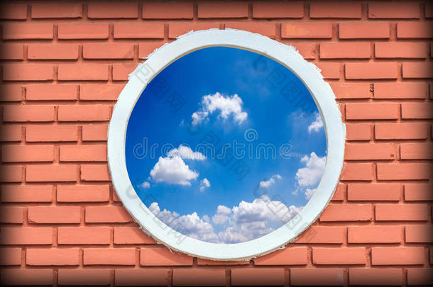 一栋<strong>砖墙</strong>建筑的圆形<strong>复古</strong>窗户映衬着蓝天小插曲在蓝色的天空中，古老的窗户