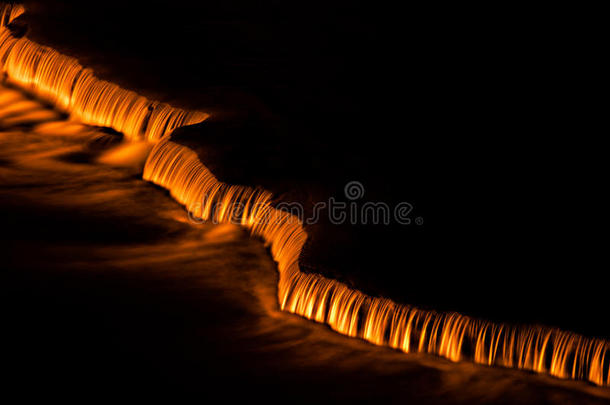 小瀑布在夜晚被橙色的灯光照亮