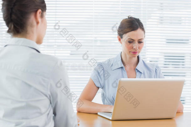 一位女商人在接受<strong>采访</strong>时看着笔记本电脑