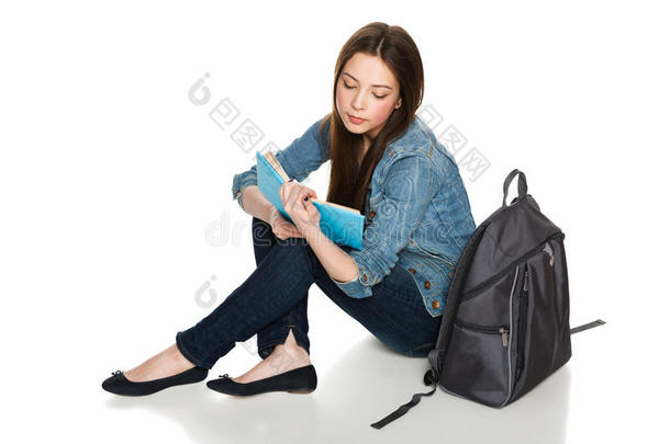 女学生<strong>背着书包</strong>坐在地上看书