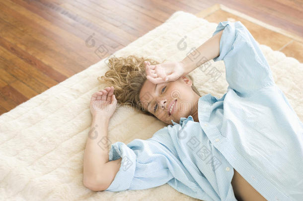 在家躺在地毯上的年轻女子