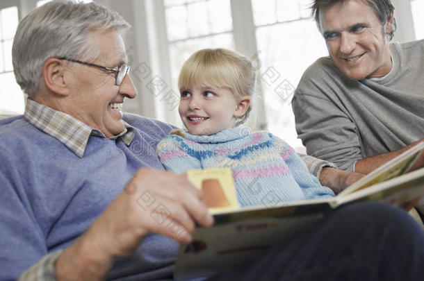 父亲和祖父一起读故事书的女孩
