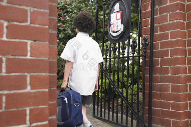 带着背包进入学校大门的男孩