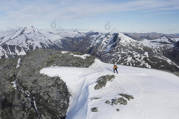 登山者穿越雪地前往遥远的山峰