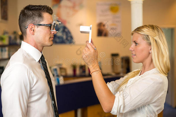 验光师或验光师测量顾客的眼距