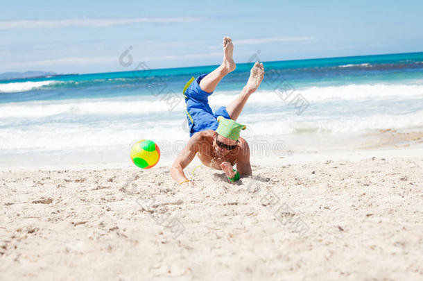 迷人的年轻人在<strong>沙滩</strong>上打<strong>排球</strong>