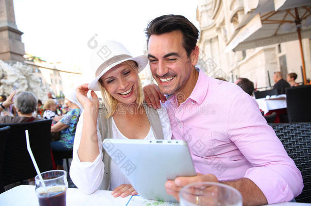 罗马咖啡馆里手持平板电脑的游客