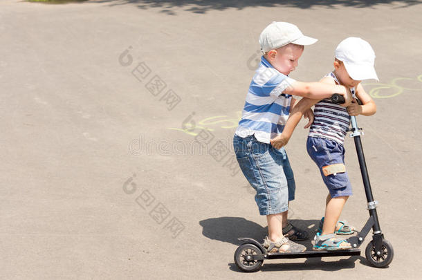 两个小男孩在玩滑板车