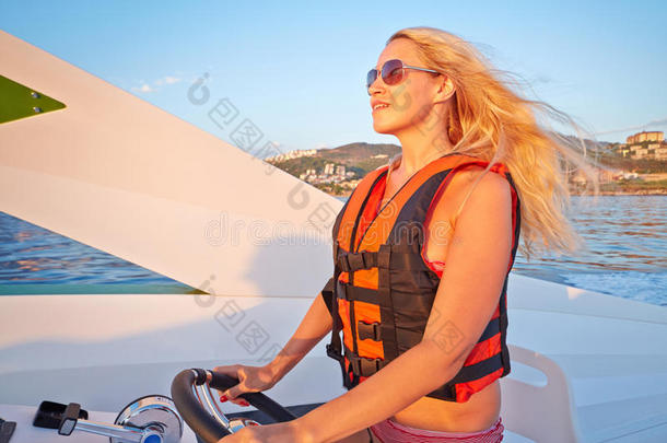 穿救生衣的妇女掌舵摩托艇
